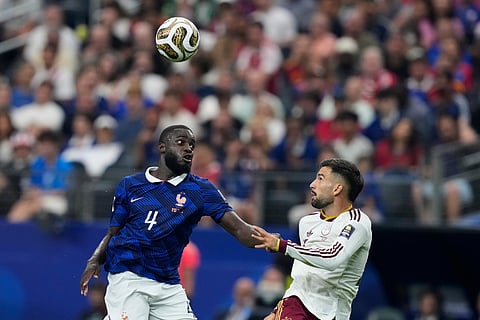 France's Dayot Upamecano (4) and Spain's Alex Baena (15) jump for the ball during the World Cup semifinal soccer match