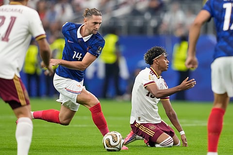France's Adrien Rabiot (14) stops Spain's Lamine Yamal (19) during the World Cup semifinal soccer match 