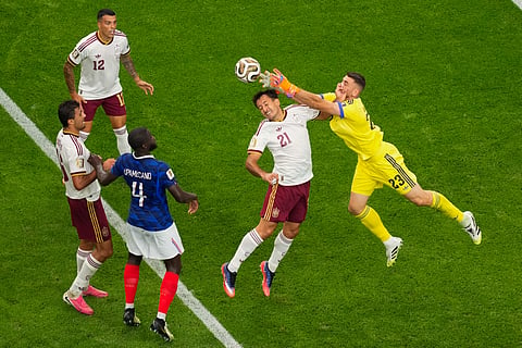Spain goalkeeper Unai Simon (23) collides with teammate Mikel Oyarzabal (21) during the World Cup semifinal soccer match between France and Spain in Arlington, Texas, near Dallas
