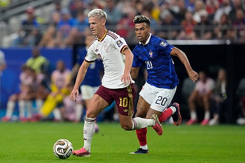 Spain's Dani Olmo (10) controls the ball as France's Desire Doue (20) runs behind him during the World Cup semifinal soccer match between France and Spain in Arlington
