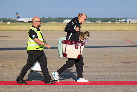 Norway's Erling Haaland, right, walks after his national soccer team landed at Oslo Airport, in Gardermoen, Norway, Monday, July 13, 2026.  