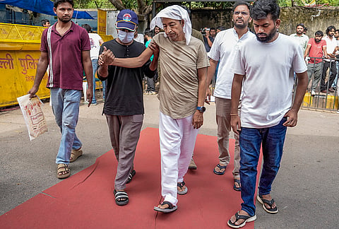 Climate activist Sonam Wangchuk being attended as Cockroach Janata Party (CJP) founder Abhijeet Dipke looks on during a protest by CJP demanding Union Education Minister Dharmendra Pradhan's resignation over alleged irregularities in the NEET examination, at Jantar Mantar, in New Delhi. Wangchuk has been on an indefinite hunger strike for 18 days. 