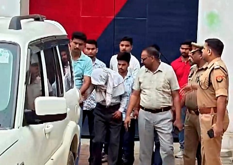 Police personnel and others with one of the accused of the Ram temple donation case outside the jail, in Ayodhya, Uttar Pradesh.
