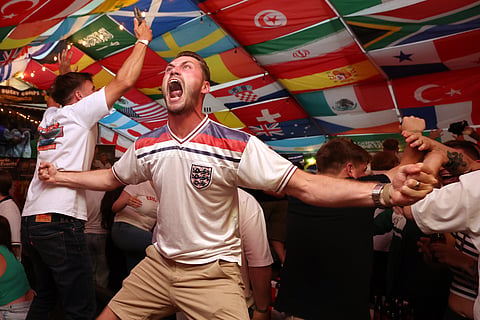 England soccer fans celebrate during the World Cup semifinal soccer match between England and Argentina at The Clock pub