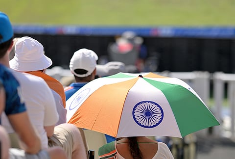 An India fan sits under an umbrella during the first ODI cricket match between England and India in Birmingham, England, Tuesday, July 14, 2026. 