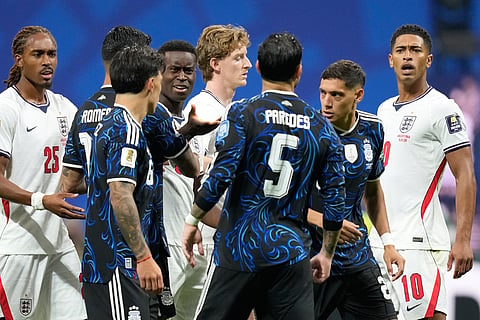 England's Marc Guehi, center, gestures to Argentina's Leandro Paredes during an argument in the first minutes of the World Cup semifinal soccer match 