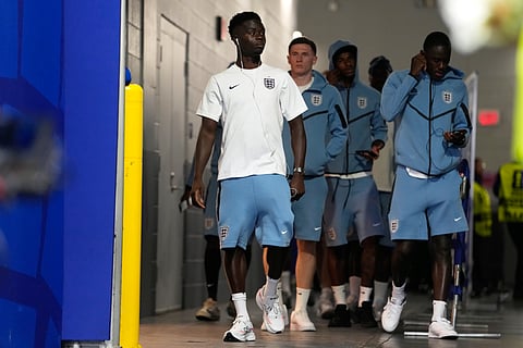 England's Bukayo Saka, left, and his teammates come on to the pitch for a walk around before the World Cup semifinal match