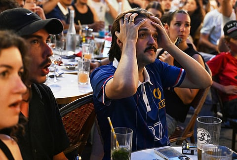 French fans react as they watch a broadcast of the World Cup semifinal soccer match between France and Spain, Tuesday, July 14, 2026, in Paris. 