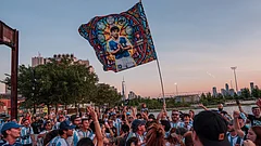 A Diego Maradona flag is held in the air as Argentina fans gather by the Hudson River ahead of their World Cup semifinal soccer match against England, Tuesday, July 14, 2026, in New York. - (AP Photo/Adam Gray)