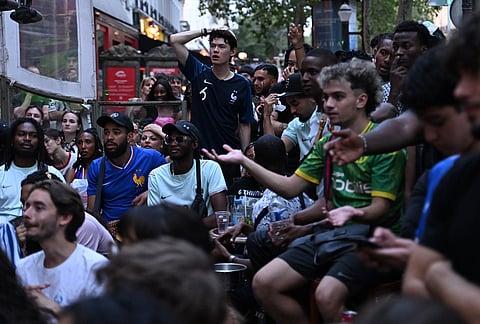 French fans react as they watch a broadcast of the World Cup semifinal soccer match between France and Spain, Tuesday, July 14, 2026, in Paris.