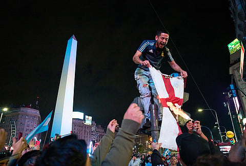 Fans burn an England flag during celebrations of Argentina's victory over England in a World Cup semifinal soccer match in downtown Buenos Aires, Argentina, Wednesday, July 15, 2026.