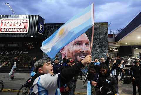 Fans celebrates in front of a mural of Lionel Messi after Argentina defeated England in World Cup semifinal soccer match, in Buenos Aires, Argentina, Wednesday, July 15, 2026. 