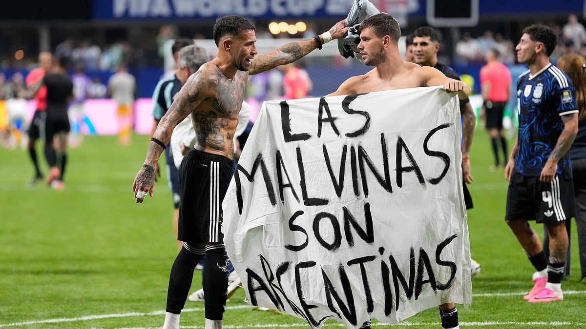 Argentina's Giovani Lo Celso holds a banner with the words "The Malvinas are Argentine", referring to the Falkland Islands, while teammate Argentina's Nicolas Otamendi gestures to him, at the end of the World Cup semifinal soccer match between England and Argentina in Atlanta, Wednesday, July 15, 2026 - (AP Photo/Rebecca Blackwell)
