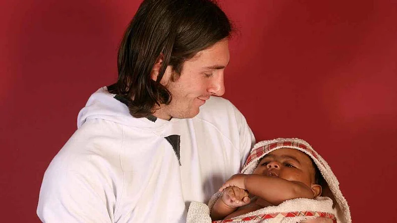 Lionel Messi holding baby Lamine Yamal
