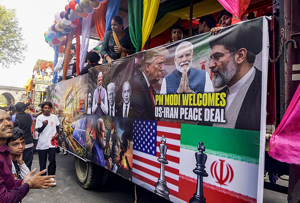 A truck with a large banner bearing images of Prime Minister Narendra Modi, US President Donald Trump and other world leaders along with text that reads, "PM Modi welcomes US-Iran Peace Deal", passes during the annual Rath Yatra festival celebration, in Ahmedabad. - | Photo: PTI
