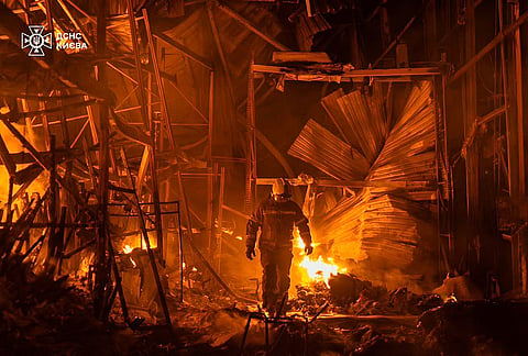 Emergency services personnel work to extinguish a fire following a Russian air attack in Kyiv, Ukraine.