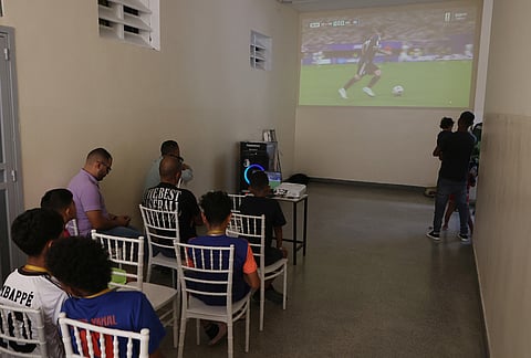 People watch the World Cup semifinal match between Argentina and England at a government-run temporary shelter for those displaced by the earthquakes in Caracas, Venezuela, Wednesday, 7 15, 2026.