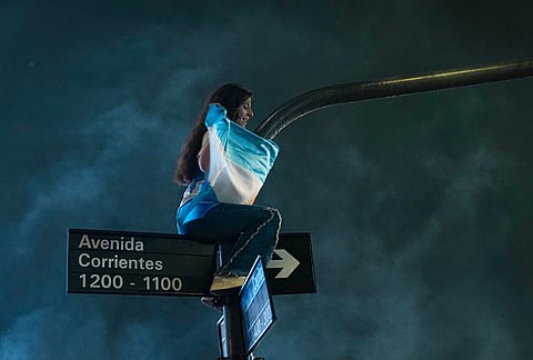A fan perches atop a traffic signal during celebrations of Argentina's victory over England in a World Cup semifinal soccer match in downtown Buenos Aires, Argentina, Wednesday, July 15, 2026.