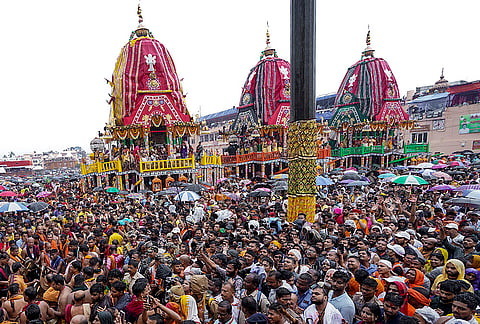 People gather during the 'Pahandi' ritual (carrying the deities Lord Jagannath, Lord Balabhadra and Goddess Subhadra from the temple sanctum to their chariots) as the annual Rath Yatra festival commences, at the Jagannath Dham in Puri, Odisha. 