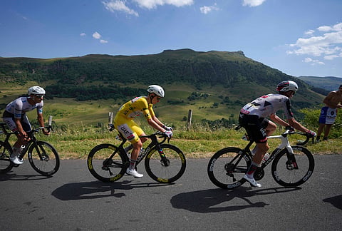 Slovenia's Tadej Pogacar, wearing the overall leader's yellow jersey, rides in the pack during the tenth stage of the Tour de France cycling race with start in Aurillac and finish in Le Lioran, France, Tuesday, July 14, 2026.