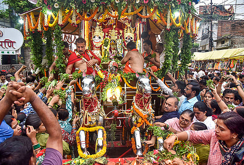 People offer prayers as a chariot carrying idols of Lord Jagannath, Lord Balabhadra and Goddess Subhadra passes through a street during the annual Rath Yatra festival, in Varanasi, Uttar Pradesh, Friday, July 17, 2026. 