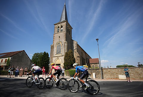 The break away riders speed past a church during the eleventh stage of the Tour de France cycling race with start in Vichy and finish in Nevers, France, Wednesday, July 15, 2026. 
