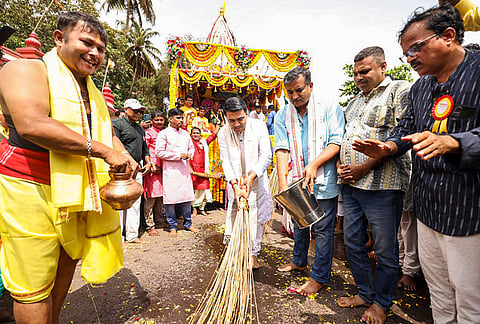 Goa Chief Minister Pramod Sawant sweeps a street with a broom as a chariot carrying idols of Lord Jagannath, Lord Balabhadra and Goddess Subhadra proceeds during the annual Rath Yatra festival, in Miramar, Goa. 