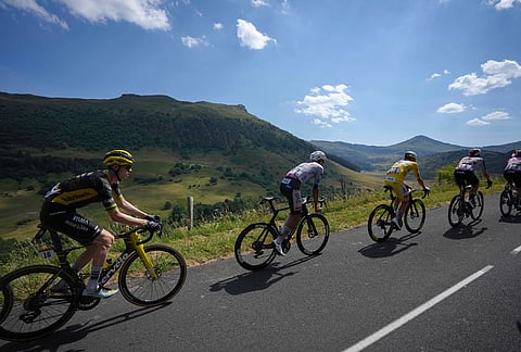 Slovenia's Tadej Pogacar, wearing the overall leader's yellow jersey, rides in the pack during the tenth stage of the Tour de France cycling race with start in Aurillac and finish in Le Lioran, France, Tuesday, July 14, 2026. 
