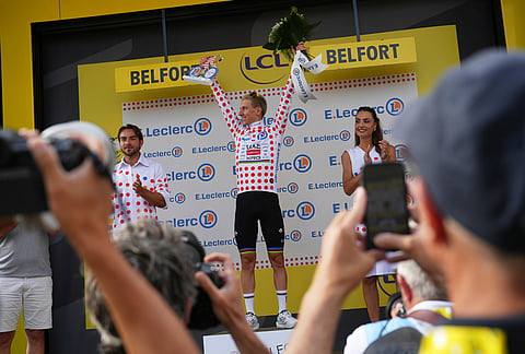 Slovenia's Tadej Pogacar, wearing the best climber's dotted jersey, celebrates on the podium after the thirteenth stage of the Tour de France cycling race with start in Dole and finish in Belfort, France, Friday, July 17, 2026. 