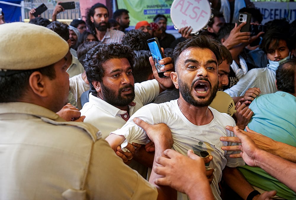Security personnel detain supporters of the Cockroach Janata Party (CJP) as they raise slogans after activist Sonam Wangchuk, unseen, who has been on an indefinite hunger strike for 21 days, is shifted to a hospital from Jantar Mantar, in New Delhi, Saturday, July 18, 2026. 