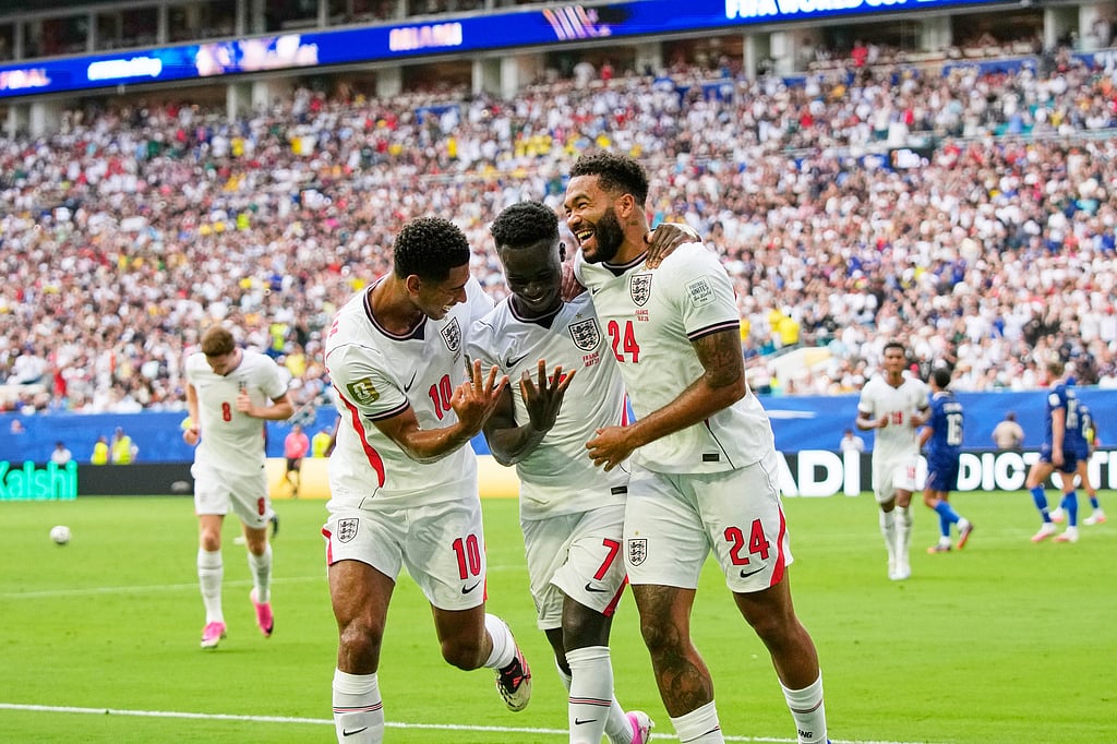 Englands Bukayo Saka (7) celebrates with Jude Bellingham (10) and Reece James (24) after scoring their fifth goal, his third, during the World Cup third-place playoff soccer match between France and England in Miami Gardens