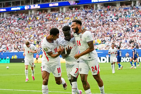 England's Bukayo Saka (7) celebrates with Jude Bellingham (10) and Reece James (24) after scoring their fifth goal, his third, during the World Cup third-place playoff soccer match between France and England in Miami Gardens