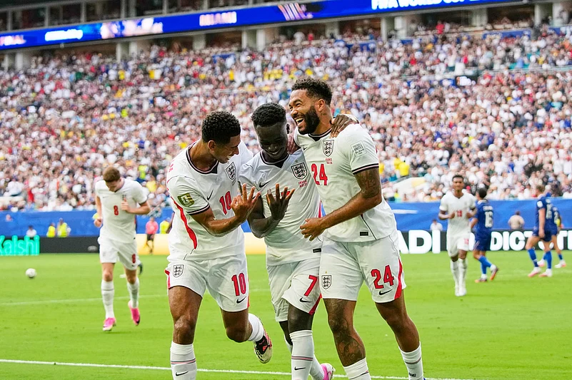 Englands Bukayo Saka (7) celebrates with Jude Bellingham (10) and Reece James (24) after scoring their fifth goal, his third, during the World Cup third-place playoff soccer match between France and England in Miami Gardens