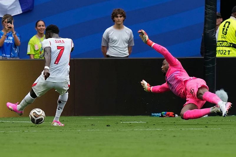 Englands Bukayo Saka (7) attempts a shot on goal as France goalkeeper Mike Maignan (16) dives during the World Cup third-place playoff soccer match between France and England in Miami Gardens,