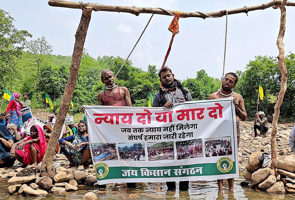 Tribals and farmers affected by the Ken-Betwa river-linking project stage a symbolic ‘hanging satyagraha’ by placing nooses around their necks demanding full rehabilitation or state-sanctioned euthanasia, in Chhatarpur district, Madhya Pradesh. - | Photo: PTI