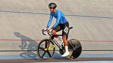 insta/harshveersekhon : Harshveer Singh Sekhon is seen riding his track bicycle on a velodrome during a training or competition session, wearing a blue long-sleeved skinsuit, black aerodynamic helmet and race number 307. Captured on the steeply banked track, the image highlights the aerodynamic position and specialized equipment used in elite track cycling, including a disc rear wheel