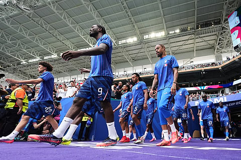 French players walk onto the pitch for warmups for the World Cup third-place playoff soccer match between France and England in Miami Garden