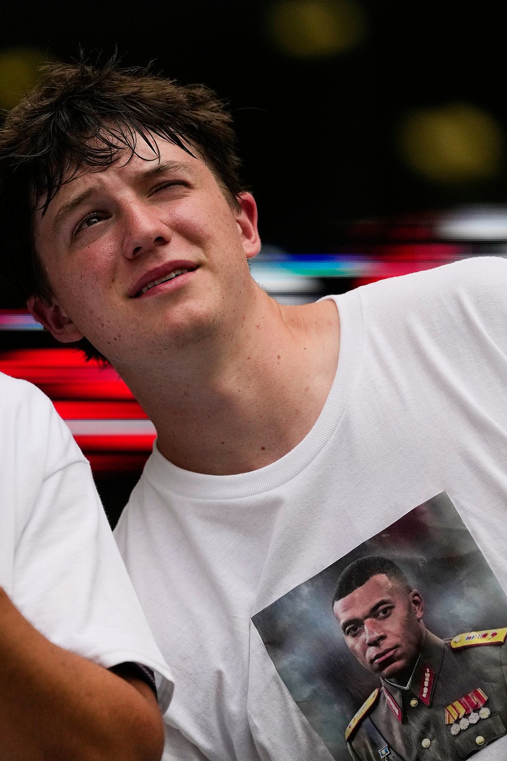 A French fan wears a shirt that shows the likeness of Frances Kylian Mbappe during the World Cup third-place playoff soccer match between France and England in Miami Gardens