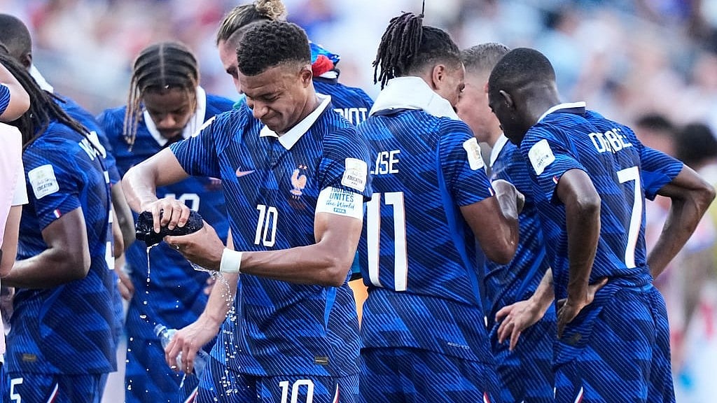 France's Kylian Mbappe (10) wrings out a towel during a hydration break in the World Cup round of 16 soccer match between Paraguay and France in Philadelphia - Matt Slocum/AP Photo