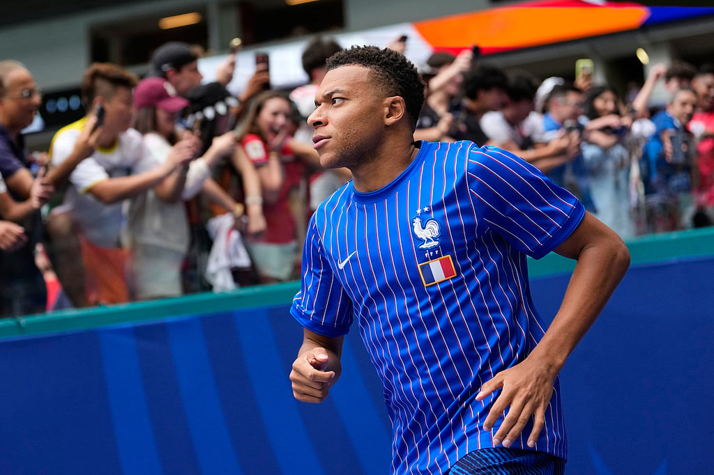 France's Kylian Mbappe jogs onto the field for warmups before the World Cup third-place playoff soccer match between France and England in Miami Gardens - Rebecca Blackwell/AP Photo