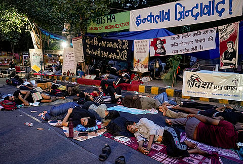Supporters of the Cockroach Janata Party (CJP) rest at Jantar Mantar before activist Sonam Wangchuk, unseen, who has been on an indefinite hunger strike for 21 days, is shifted to a hospital for medical care, in New Delhi, early Saturday, July 18, 2026. 
