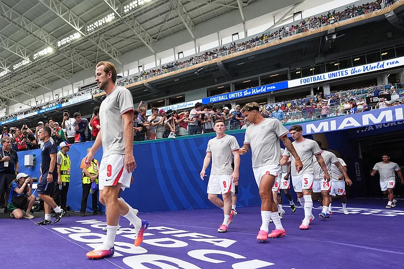 Englands Harry Kane (9) and Elliot Anderson (8) lead the team onto the pitch for warmups before the World Cup third-place playoff soccer match between France and England in Miami Gardens