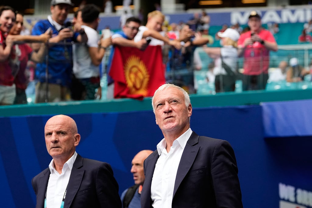 France head coach Didier Deschamps, center, walks onto the pitch with staff as fans look on before the World Cup third-place playoff soccer match between France and England in Miami Gardens