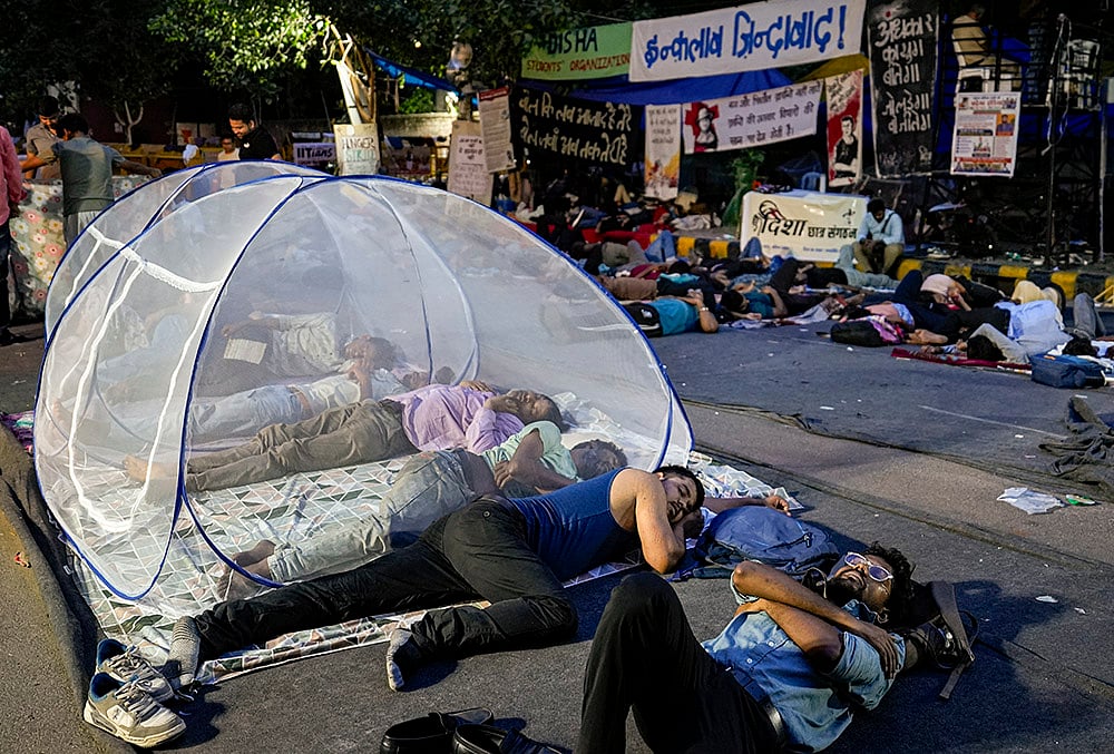 Supporters of the Cockroach Janata Party (CJP) rest at Jantar Mantar before activist Sonam Wangchuk, unseen, who has been on an indefinite hunger strike for 21 days, is shifted to a hospital for medical care, in New Delhi, early Saturday, July 18, 2026. 