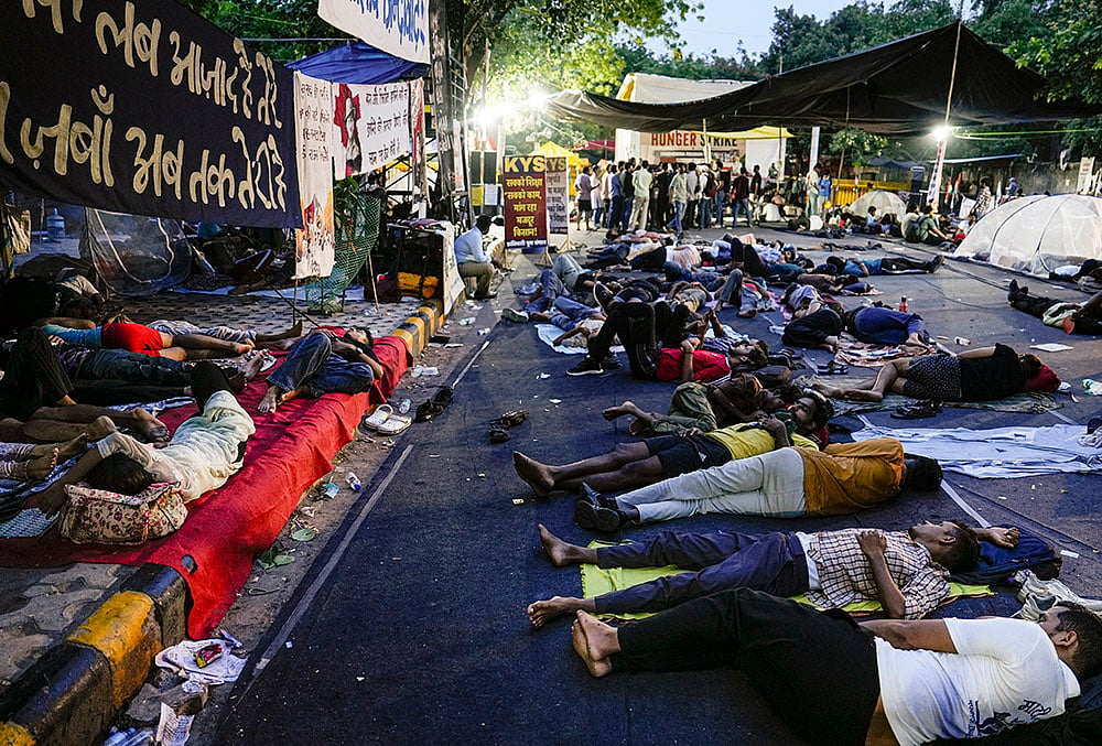 Supporters of the Cockroach Janata Party (CJP) rest at Jantar Mantar before activist Sonam Wangchuk, unseen, who has been on an indefinite hunger strike for 21 days, is shifted to a hospital for medical care, in New Delhi, early Saturday, July 18, 2026. 
