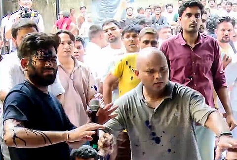 Cockroach Janata Party (CJP) founder Abhijeet Dipke reacts after a woman threw an ink-like liquid on him as he begins an indefinite hunger strike at Jantar Mantar, in New Delhi.