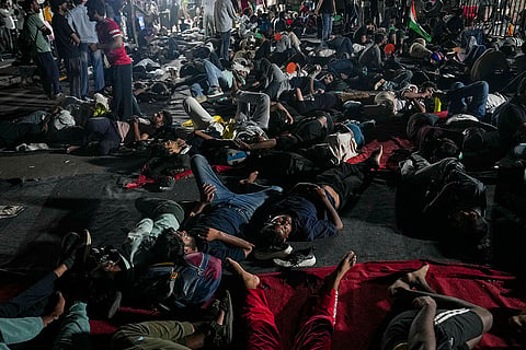 Cockroach Janata Party (CJP) supporters rest during a protest demanding Union Education Minister Dharmendra Pradhan's resignation over alleged irregularities in the NEET examination, at the Jantar Mantar, in New Delhi, Sunday, July 19, 2026.