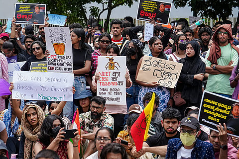 Cockroach Janata Party (CJP) supporters hold placards and stage a protest demanding Union Education Minister Dharmendra Pradhan's resignation over alleged irregularities in the NEET examination, in Bengaluru, Karnataka, Sunday, July 19, 2026.