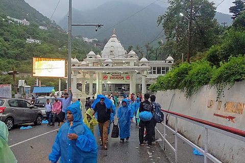 People gather near the Banganga entry gate after the Shri Mata Vaishno Devi Shrine Board suspends the pilgrimage due to adverse weather conditions, in Katra, Jammu and Kashmir.
