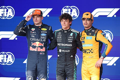 Mercedes driver Andrea Kimi Antonelli of Italy, center, stands on the podium with second place Red Bull driver Max Verstappen of the Netherlands, left, and third place McLaren driver Lando Norris of Britain after clocking the fastest time during the qualifying session ahead of the Formula One Grand Prix at the Spa-Francorchamps racetrack in Spa, Belgium.